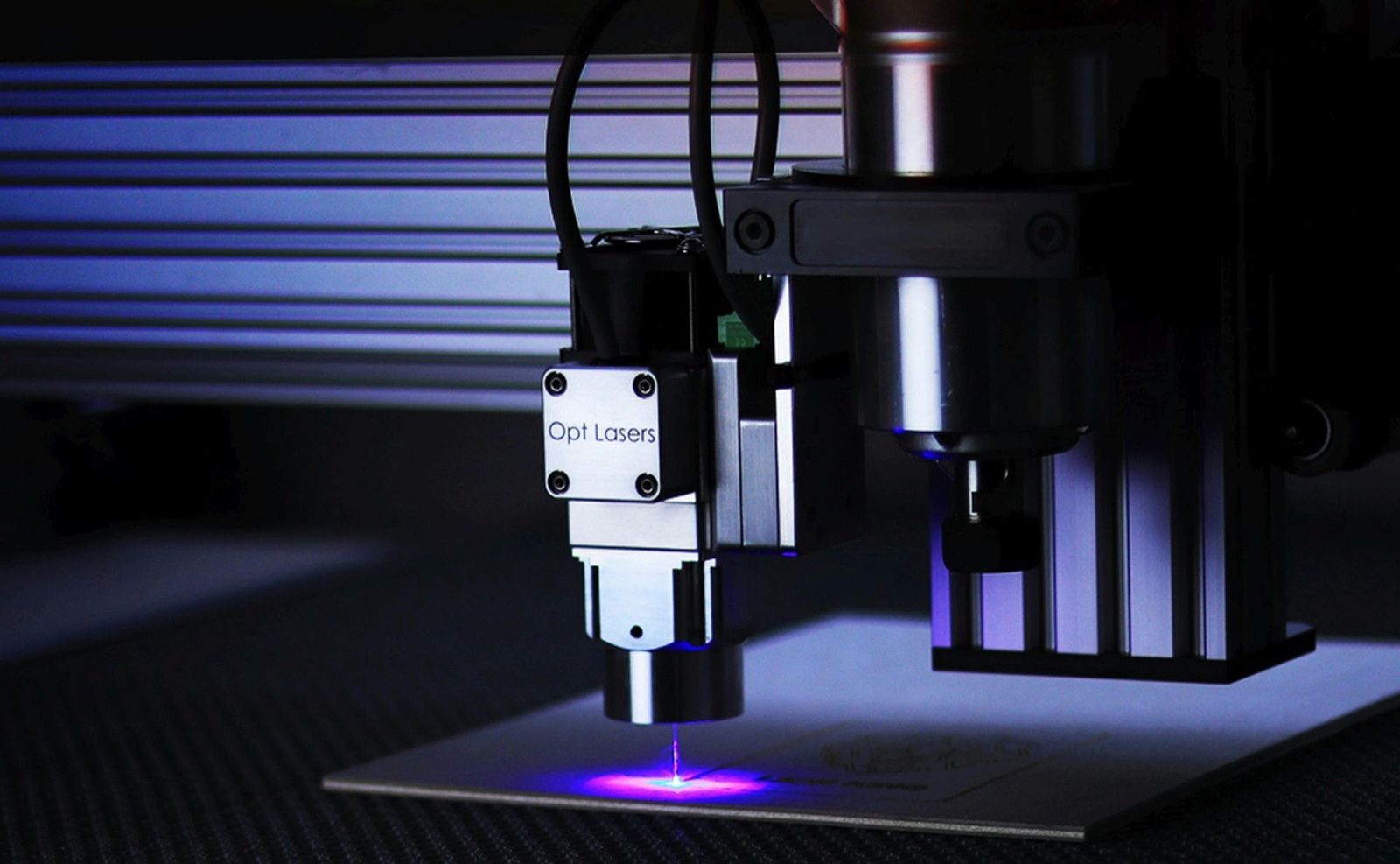 CO2 laser cutter — close-up of laser head in operation