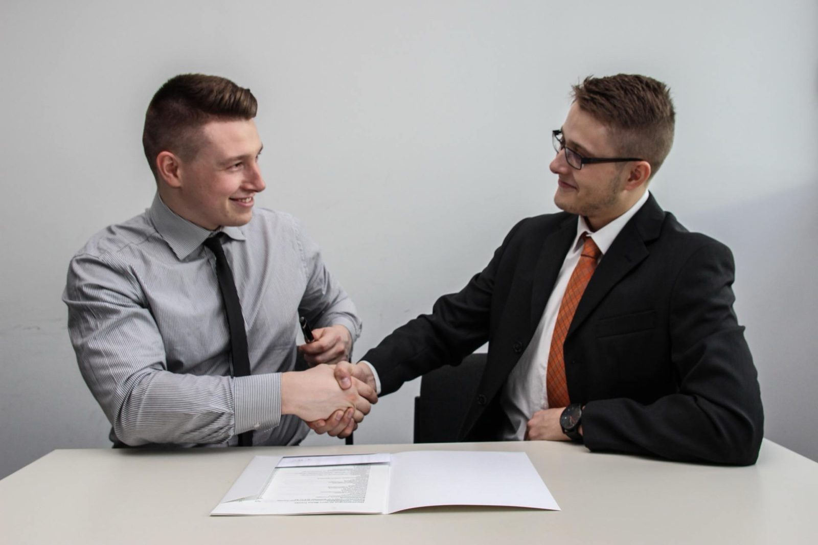 A man in a suit shakes hands with another man